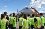 　旅客機への荷物の積み込み作業を見学する高校教員ら＝３日午後、成田空港