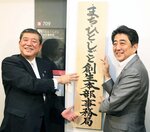 ２０１４年９月、「まち・ひと・しごと創生本部事務局」の看板を掛ける安倍首相（右）と石破地方創生相＝東京・永田町の中央合同庁舎