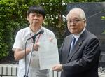 　武見厚労相（当時・右）に要望書を手渡す薬被連の花井十伍代表世話人＝８月、厚労省