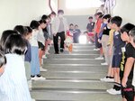 子どもたちが見守る中、階段を下りる野沢さんとパル