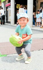 自分の顔ほどの大きさのキャベツを抱える男の子。会場には親子連れの姿が目立った