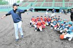 上本さん（左）から守備などの助言を受ける子どもたち＝１１日、鳥取市布勢のヤマタスポーツパーク野球場