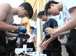 ウニの身を取り出して重さを計測する生徒ら＝１８日、鳥取市青谷町長和瀬の長和瀬漁港