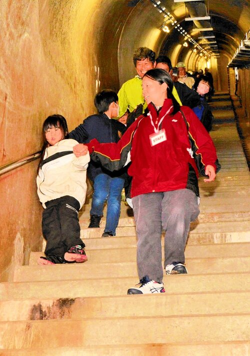 下蚊屋ダム内部の急な階段を慎重に下りる参加者