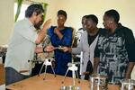 　ケニア中西部ナクル県で、県の担当者に蚊取り線香の作り方を教える飯尾裕光さん（左端）＝３月（本人提供）