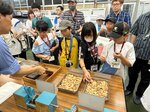 大王製紙三島工場で紙の原料であるチップに触れる参加児童たち