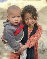 　アフガニスタンの首都カブール西郊の避難民キャンプに暮らす弟を抱いたナズダナ＝２０２３年１１月１７日（共同）