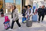 　東京・銀座でスーツケースを手に歩く外国人ら＝１７日午後