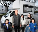 キッチンカーで焼き鳥を販売する遠藤さん一家。車両のデザインはこれから＝２０日、米子市両三柳の新日本海新聞社西部本社