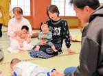 参加者の赤ちゃんの面倒を見る川口代表（中央）ら＝１１日、新温泉町湯の温泉旅館「湯村温泉　とみや」