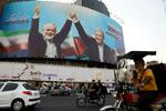 　イスラム組織ハマスのハニヤ最高指導者（左）と手をつなぐイランのペゼシュキアン大統領の看板＝５日、イラン・テヘラン（ＡＰ＝共同）