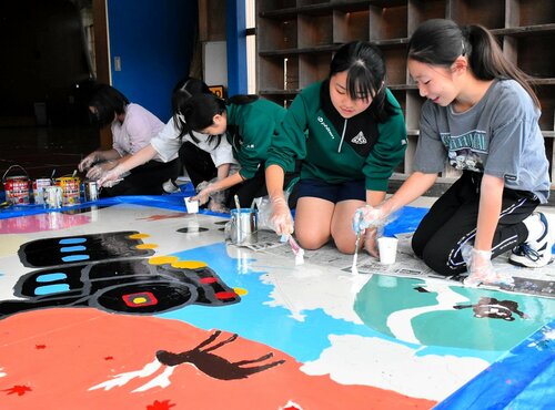 階段アートの板にペンキを塗り、カラフルに仕上げていく生徒