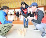 ルール共有　木の棒を投げて木製のピンを倒すフィンランド発祥の新スポーツ「モルック」のルールを確認するスタッフ。裏方も大変です