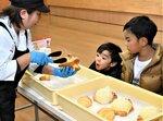 自らが作ったパンの焼き上がりを喜ぶ子ども＝２４日、鳥取市浜坂のアイエム電子鳥取砂丘こどもの国