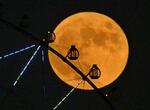 　東京都江東区から見られた「中秋の名月」。手前は葛西臨海公園の大観覧車＝２９日午後５時５４分