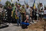 　ロシア軍に殺害された犠牲者の墓前で悲しむ女性＝１８日、ウクライナの首都キーウ近郊ブチャ（ＡＰ＝共同）