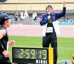 自身も持つ「サブ３」の達成者に声援を送るハリーさん（右）＝ヤマタスポーツパーク陸上競技場