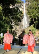 　熊野那智大社のご神体「那智の滝」の前で舞を披露する巫女＝１４日午前、和歌山県那智勝浦町