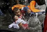 　トルコからエーゲ海を渡ってギリシャのレスボス島に到着したシリア難民の親子＝２０１５年９月（ロイター＝共同）