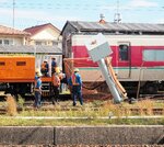 開閉型のフェンスと接触した車両の復旧作業に当たる関係者ら＝１５日、鳥取県米子市日ノ出町２丁目の後藤総合車両所