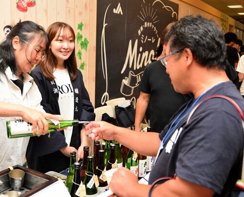 鳥取の地酒を試飲する参加者（右）