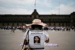 　メキシコ市で、失踪中の娘に関する情報提供を求める看板を背負った女性＝５月１０日（ＡＰ＝共同）
