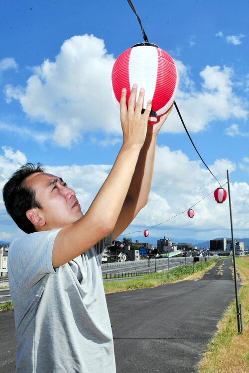 台風の行方を注視しながら花火大会の会場設営に励むスタッフ＝１２日、鳥取市古市