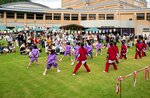 緑の芝生の上で披露されたオープニングのダンスを楽しむ町民ら