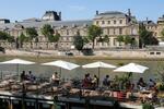 　セーヌ川沿いのカフェに座った人々＝７月２９日、パリ（タス＝共同）