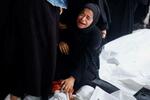 　イスラエル軍による攻撃の犠牲者となった遺体のそばで泣く人＝６日、パレスチナ自治区ガザ南部ラファ（ロイター＝共同）