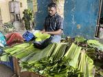 　インド南部チェンナイの青物市場でバナナの葉を売る店主ジェッビット・ラージさん＝２０２４年５月（共同）