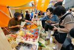 　石川県輪島市内の商業施設で出張開催された輪島朝市で、野菜や果物を買い求める客ら＝１０日午前