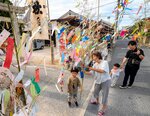 七夕飾りを奉納する家族ら＝７日、米子市内町の宇気河口神社