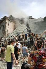 　８日、ロシアの攻撃を受け、一部建物が崩壊したウクライナ・キーウの小児病院。多くの人々が救助活動に当たった（共同）