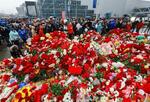 　２４日、モスクワ郊外クラスノゴルスクで、銃乱射テロの現場近くに追悼の花を手向ける市民ら（タス＝共同）