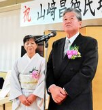 妻の幸代さんと一緒に感謝の気持ちを述べる山崎さん（右）