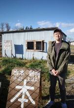 　自宅の納屋を改装した「ＮＡＹＡ　ＢＯＯＫＳ」の前に立つ高田直樹さん＝２０２４年１月、栃木県那須烏山市