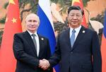 　会談で握手を交わすロシアのプーチン大統領（左）と中国の習近平国家主席＝１８日、北京（ロイター＝共同）