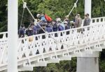 　女子高校生がつり橋から川に落とされ殺害された事件の現場で実況見分する捜査員ら＝６月、北海道旭川市