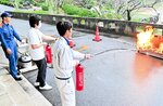 消火器を使って放水訓練を行う職員ら