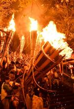 　京都市左京区の由岐神社一帯で行われた「鞍馬の火祭」。締め込み姿の若者らが燃え盛るたいまつを担いで練り歩いた＝２２日夜