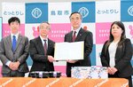 調印した協定書を持つ北垣社長（左から２人目）と深沢市長＝１０日、鳥取市役所