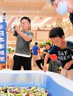 お菓子釣りゲームに夢中になる子どもたち＝３０日、鳥取市晩稲のイオンモール鳥取北