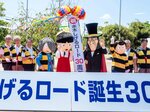 くす玉を割って妖怪の着ぐるみと３０周年を祝う関係者ら＝１６日、境港市大正町