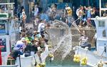 　船上からバケツなどで水をかけ合う「潮かけ祭り」の参加者たち＝１８日、三重県志摩市の和具漁港（中日新聞社提供）