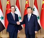 　シリアのアサド大統領（左）と握手する中国の習近平国家主席＝２２日、中国浙江省杭州（新華社＝共同）