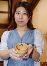 　パンダが描かれた木曽漆器のコップを手にする手塚希望さん＝７日、長野県塩尻市