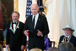 　ケネディ・センター名誉賞を受賞したビリー・クリスタルさん（左）やバリー・ギブさん（右）らをホワイトハウスに招いたバイデン米大統領＝３日、ワシントン（ＡＰ＝共同）