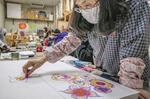 　作品作りに取り組む「造形教室」の参加者。画用紙に描いた下絵を基に、キャンバスに丁寧に花びらを描いていく＝２０２４年３月、東京・八王子の平川病院