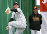 　藤川監督（奥）が見つめる中、ブルペンで投げ込む阪神・村上＝宜野座